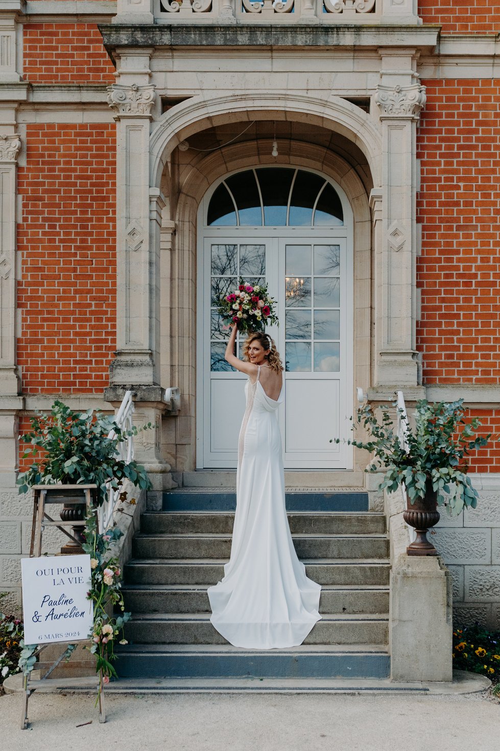 Mariage dans le nord de la France par Marine Derache photographe  représentant la mariée de 3/4 qui va lancer son bouquet. Lieu : chateau de Bac-Saint-Maur.