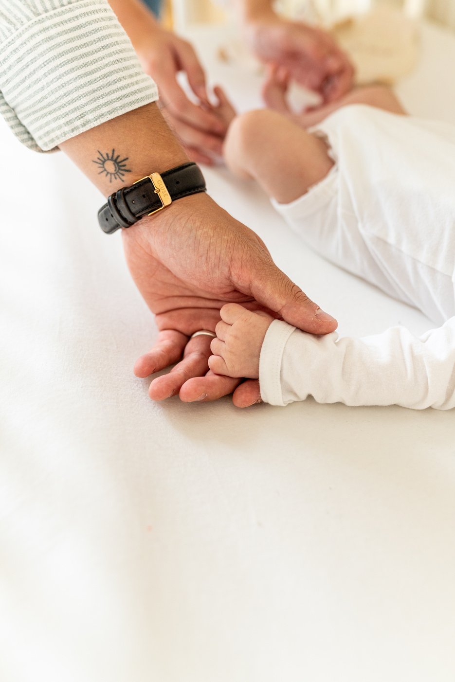 Photographie de la main d'un papa tatoué avec son fils, dans le nord de la France par Marine Derache photographe. 